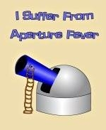 This zany astronomer shirt design shows an observatory with a gigantic telescope that's way too big for its housing. The caption says: "I Suffer From Aperture Fever."